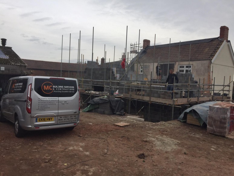 M C Building Services van on site beside the scaffolding