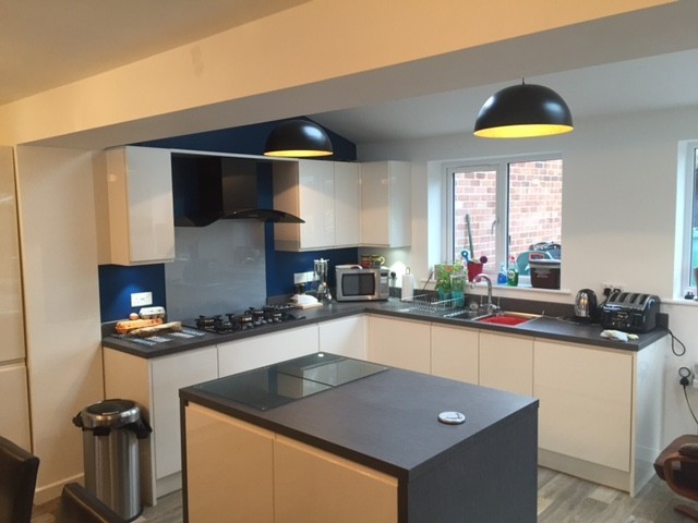 Kitchen island with black worktop and pendant lights