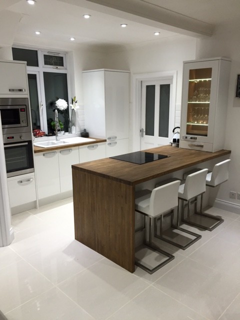 White kitchen with a timber-clad island and bar stools