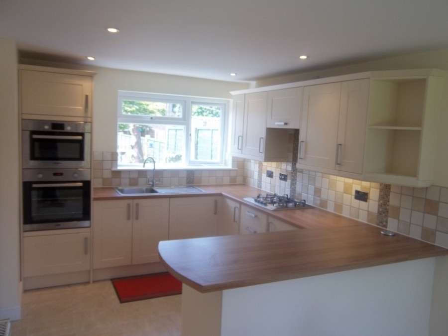 Cream kitchen with oak worktops and a breakfast bar