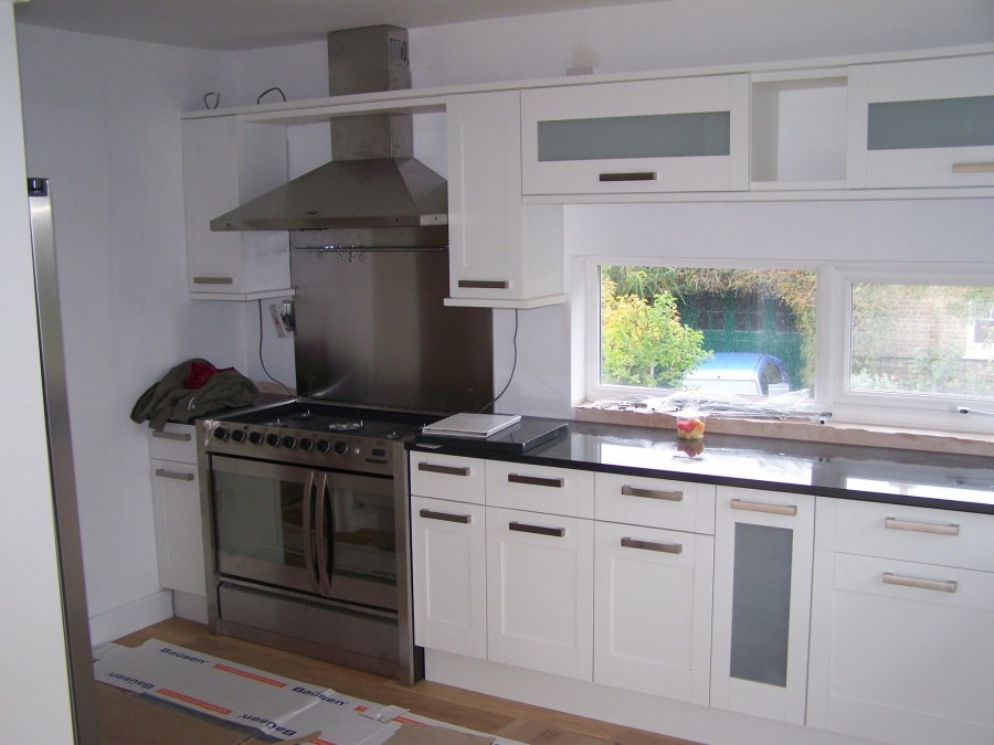 White kitchen with a range cooker and stainless splashback