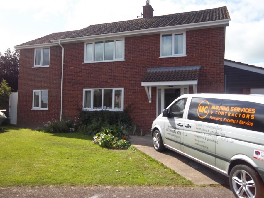M C Building Services van outside a finished house