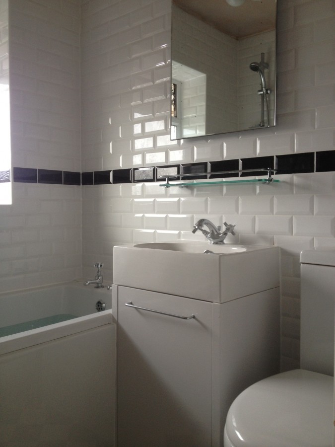 Metro tiles with a black border above a vanity unit