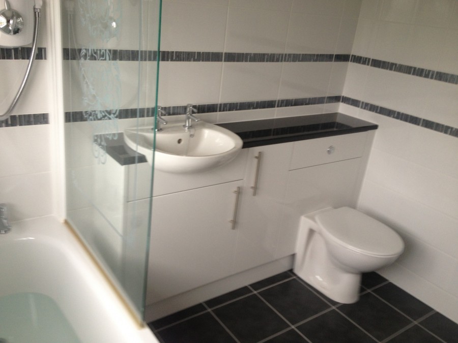 Bathroom with glass screen, vanity unit and tiled border