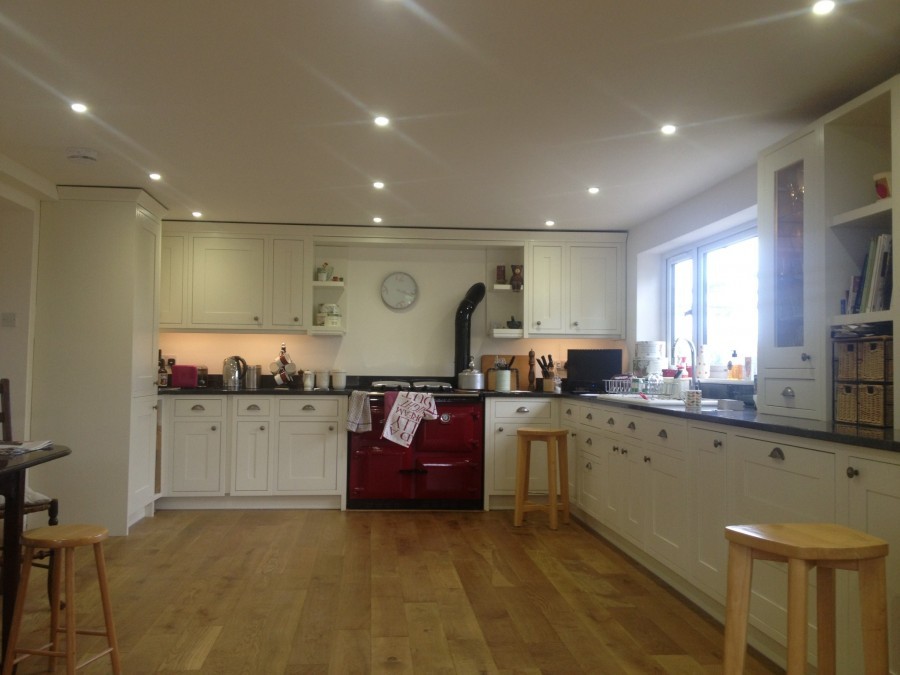 Large farmhouse kitchen with a red range cooker and oak floor