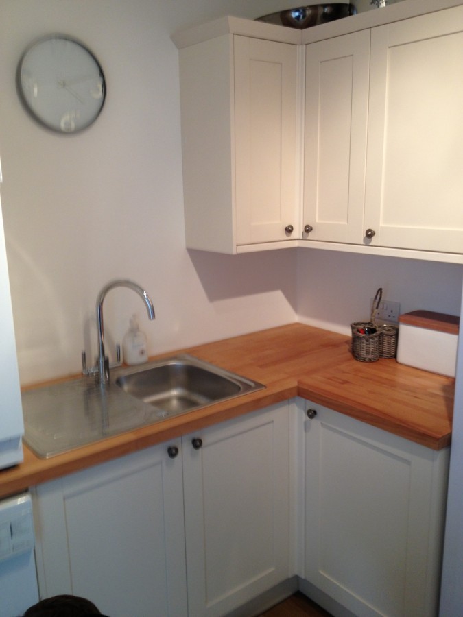 Corner sink with timber worktop in a white kitchen