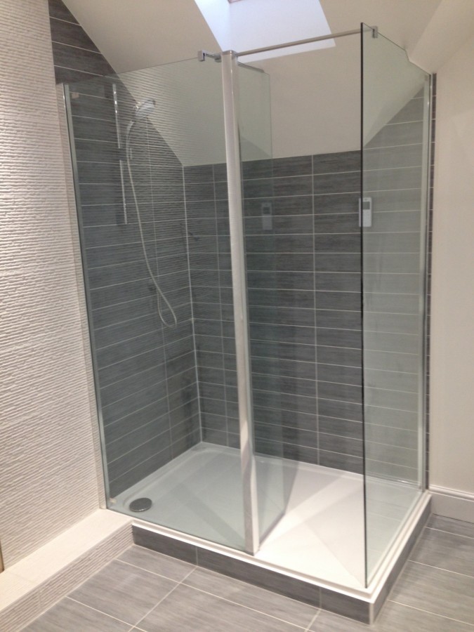 Corner shower enclosure with grey tiles
