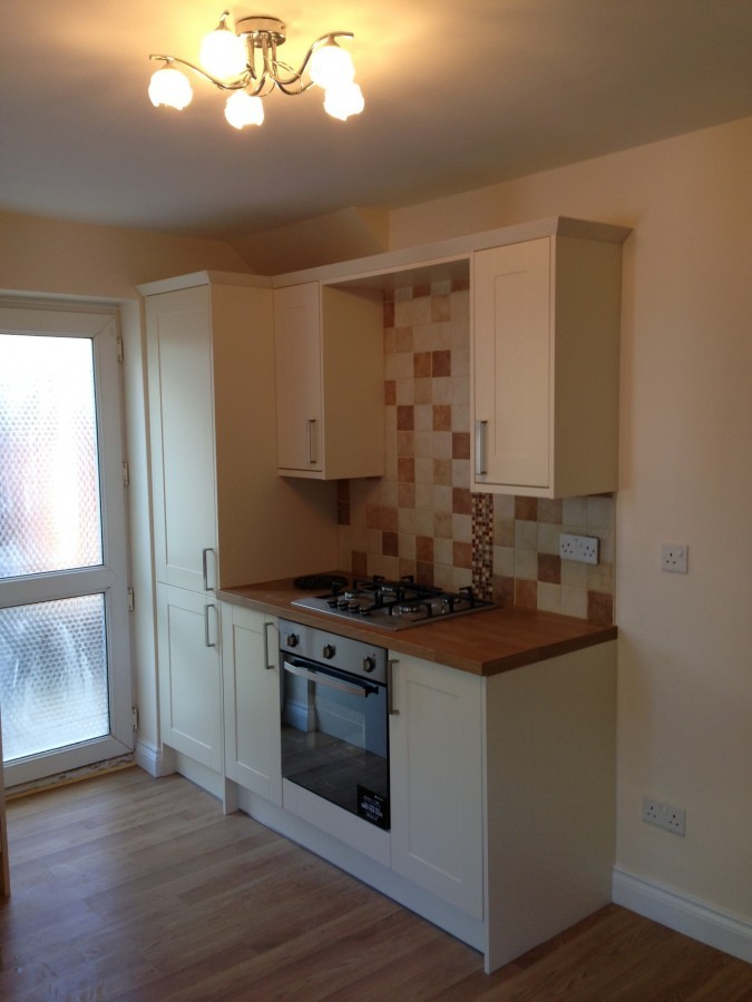 Compact cream kitchen with tiled splashback