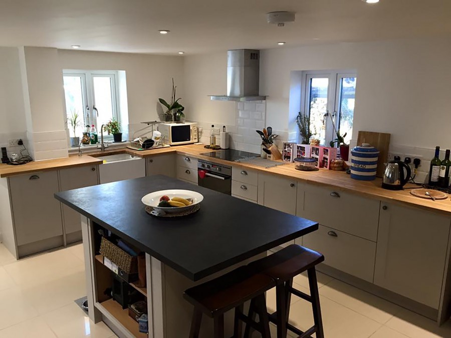 Kitchen island with black top and wooden worktops