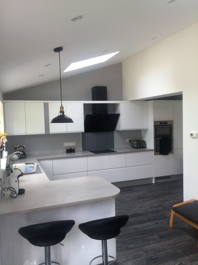 Modern white kitchen with a rooflight and bar stools